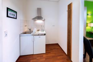 a small white kitchen with a sink and a counter at AMH Airport-Messe-Hotel Stuttgart in Filderstadt