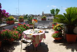 a table and chairs on a balcony with flowers at B&B Corte Barocca in Lecce