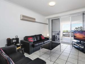 a living room with a couch and a flat screen tv at Nelson Towers, 9,71a Victoria Parade - unit in the heart of Nelson Bay with water views, air conditioning and Wi-Fi in Nelson Bay