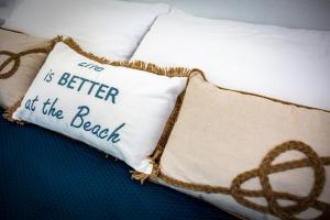 Una almohada que dice que la vida es mejor en la playa en Hotel Ariadimari en Valledoria