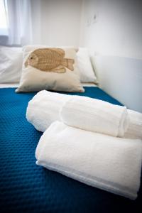 dwa stosy ręczników siedzące na łóżku w obiekcie Hotel Ariadimari w mieście Valledoria
