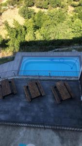 una piscina con 3 mesas de madera y una piscina en Saint Christophe, en Omessa