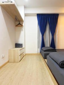 1 dormitorio con cama y cortina azul en Amadel Residence 爱媄德民宿 13, en Melaka