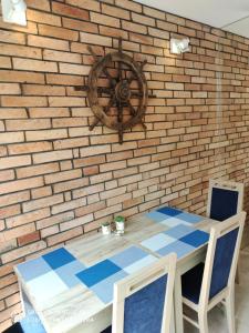 stół i krzesła przed ścianą z cegły w obiekcie Pokoje Gościnne Pod Kasztanami w Łebie