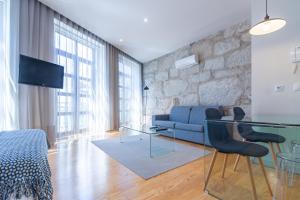 a living room with a blue couch and a glass table at Oporto Near Apartments in Porto