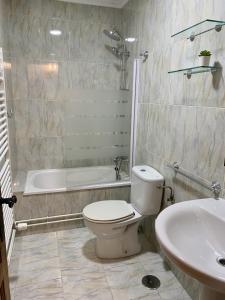 Apartamentos La Posada de Abanillas في Abanillas: حمام مع مرحاض وحوض استحمام ومغسلة