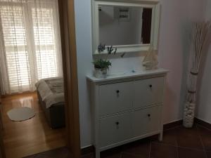 een badkamer met een witte dressoir met een spiegel bij Apartments San Marino in Novi Vinodolski