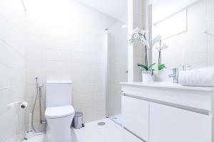 a white bathroom with a toilet and a sink at Oporto Near Apartments in Porto