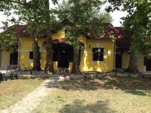 a yellow house with trees in front of it at Harmónia Apartmanház in Balatonlelle