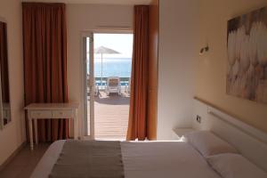 a bedroom with a bed and a view of the ocean at Villa TURQUESA MAR in Cala en Forcat