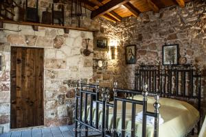 a bedroom with a bed in a stone wall at B&B Pergulea in Sternatia