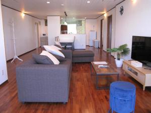 ein Wohnzimmer mit einem Sofa und einem Tisch in der Unterkunft ホテル ハイビスヤブ in Nago