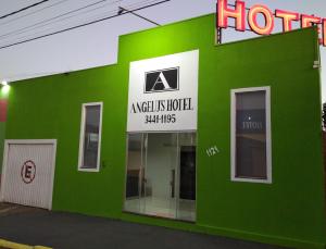 a green building with a hotel sign on it at Angelu's Hotel in Nova Andradina