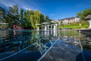 a swimming pool with a fountain in the middle at Hôtel L'Incomparable by Les Etincelles in Tresserves