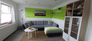 ein Wohnzimmer mit einer Couch und einem Tisch in der Unterkunft FeWo Hafner "Zuhause mit Ausblick" in Schnaittach