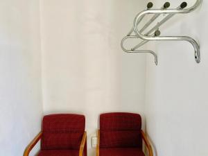 two red chairs in a waiting room at Glades Motel - Naples in Naples