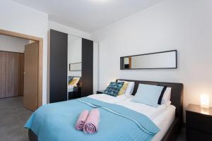 - une chambre avec un lit et 2 serviettes roses dans l'établissement GDAŃSK, Długie Ogrody 18 - Rooftop Terrace, parking, à Gdańsk