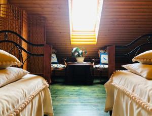 a room with two beds and a table and a window at Villa Lotus in Zhemoytele