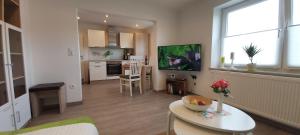 ein Wohnzimmer mit Tisch und Küche in der Unterkunft FeWo Hafner "Zuhause mit Ausblick" in Schnaittach