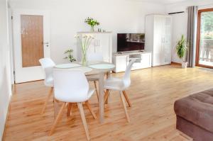 sala de estar con mesa y sillas blancas en FeWo Nelly Marie Wohnung Nelly, en Hademstorf