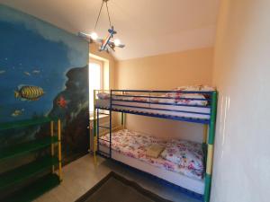 sypialnia z 2 łóżkami piętrowymi i malowidłem rybnym w obiekcie Dom nad Jeziorem Rożnowskim w mieście Tęgoborze