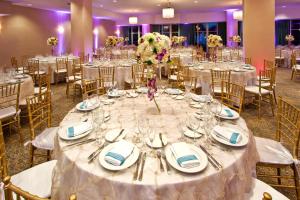 einen Tisch für eine Hochzeit mit Tellern und Besteck in der Unterkunft Holiday Inn Miami Beach-Oceanfront, an IHG Hotel in Miami Beach