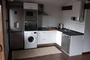 a kitchen with a refrigerator and a washing machine at Aptos Cama del Rey ideal parejas in Santander