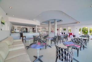a restaurant with tables and chairs and a bar at Pantheon Hotel in Perivolos
