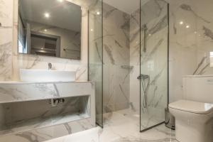 a bathroom with a shower and a sink and a toilet at Mariposa Apartments next to the Sea in Sidari