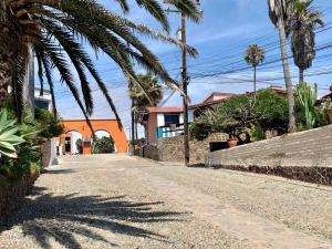 an empty street with palm trees and houses at Rosarito Beach House-- Spacious, Central, Beach View, & Sleeps 14 in Rosarito