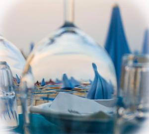 a table with a blue and white plate and glasses at Hotel Atlantic Riviera Mare in Misano Adriatico