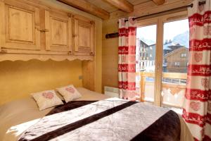 1 dormitorio con cama y ventana grande en Chalet Faverot 1, en Les Deux Alpes