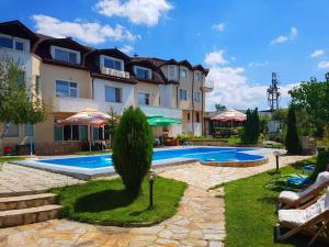 a hotel with a swimming pool in front of a building at Hotel Zenit Satovcha in Satovcha