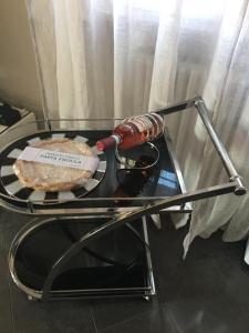 a glass table with a sandwich and a bottle on it at Casa Elite in Bardolino