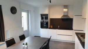 a kitchen with a wooden table and a dining room at villa Pinson in De Panne