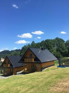 a large wooden house with a gambrel roof at DOMKI STROME ZACISZE in Niedzica Zamek