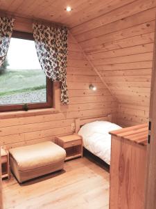 a bedroom with a bed and a window in a cabin at DOMKI STROME ZACISZE in Niedzica Zamek