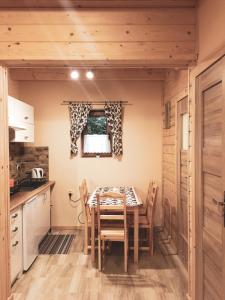 a dining room with a table and chairs in a kitchen at DOMKI STROME ZACISZE in Niedzica Zamek