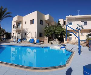 una gran piscina frente a un edificio en C & A Hotel Apartments, en Polis Chrysochous