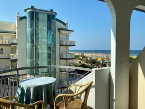 balcone con tavolo, sedie e vista sull'oceano di Hotel Moderno - Bed & Breakfast a Cervia
