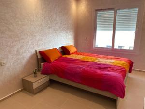 a bedroom with a bed and a window at Sunset Beach in Plage de Mehdia