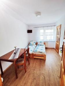 a room with two beds and a wooden table at Morska Fala in Karwia