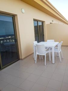 een witte tafel en stoelen op een balkon bij Apartamento con maravillosas vistas en primera línea in La Restinga