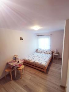 1 dormitorio con 1 cama y 1 mesa con 2 sillas en Morska Fala, en Karwia