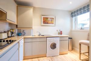 a kitchen with a washer and dryer in it at The Botanist Apartment Edinburgh Old Town 2 Bedroom Lift Parking previously The Parkgate Residence in Edinburgh
