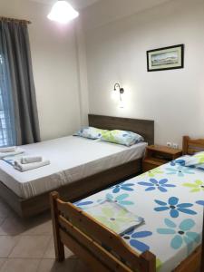 a bedroom with two beds and a window at Giorgos Apartments Square in Nea Vrasna