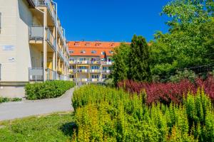 a building with a garden in front of a building at Apartament Madam in Stegna