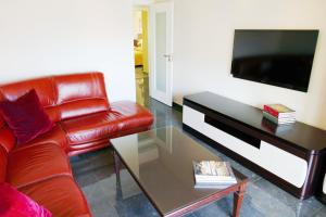 a living room with a red leather couch and a coffee table at Baleal poolfront apartment in Baleal