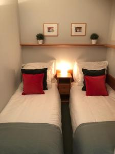 two beds with red pillows in a room at Apartment Axams in Innsbruck