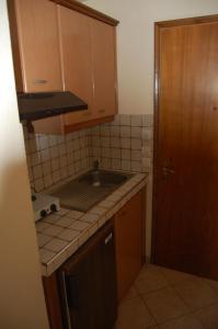 a small kitchen with a sink and a counter top at Giorgos Apartments Square in Nea Vrasna